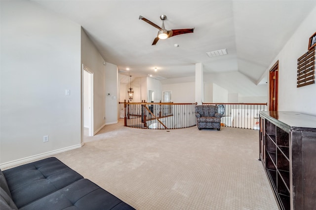 sitting room featuring vaulted ceiling, visible vents, an upstairs landing, carpet flooring, and ceiling fan