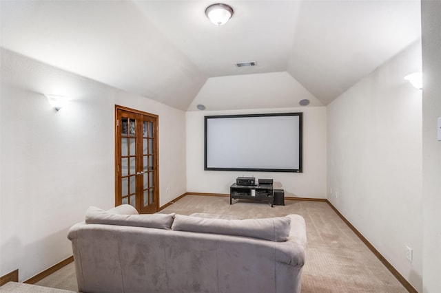 home theater room featuring light carpet, french doors, vaulted ceiling, visible vents, and baseboards