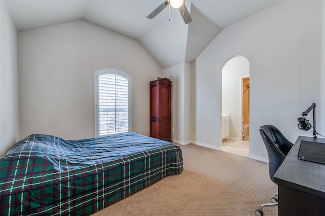 carpeted bedroom featuring arched walkways, vaulted ceiling, baseboards, a ceiling fan, and connected bathroom