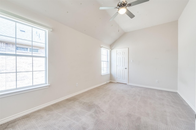 spare room with vaulted ceiling, a ceiling fan, baseboards, and light carpet