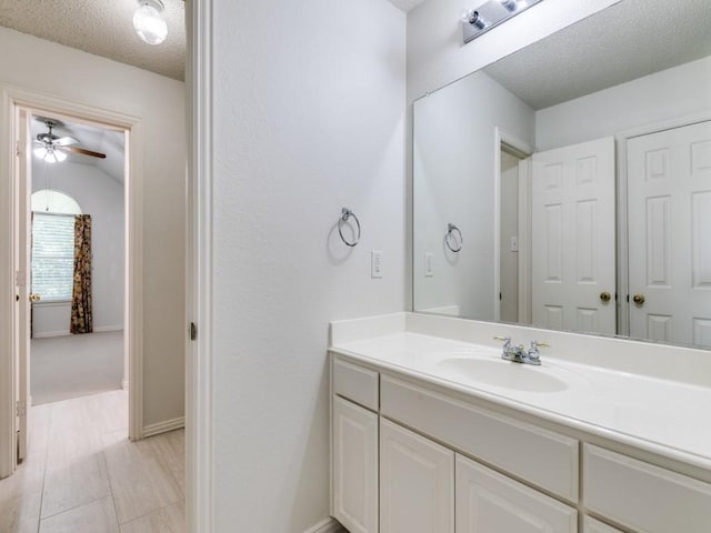 8317 Spring Valley Ln, Plano, TX 75025 - bathroom featuring baseboards, a textured ceiling, vanity, and ceiling fan