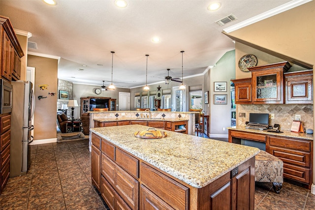 kitchen with a large island with sink, open floor plan, stainless steel appliances, baseboards, and decorative backsplash