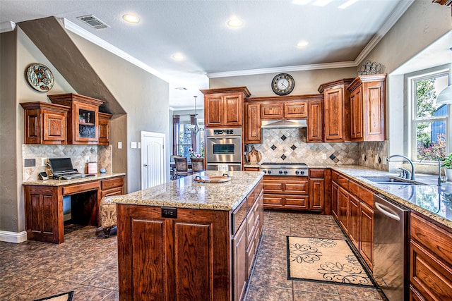 kitchen with appliances with stainless steel finishes, a sink, light stone counters, tasteful backsplash, and under cabinet range hood
