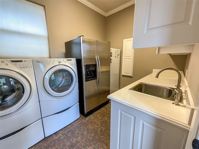 laundry room with ornamental molding, washer and clothes dryer, and dark tile patterned floors