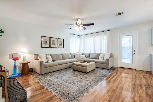 living area featuring visible vents, ceiling fan, and wood finished floors