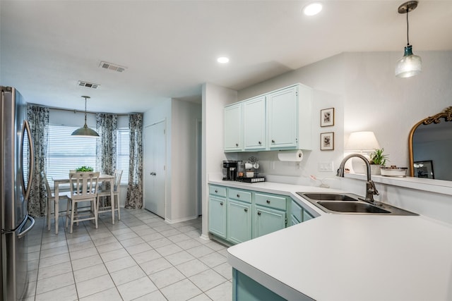 kitchen with visible vents, light tile patterned floors, a sink, and freestanding refrigerator