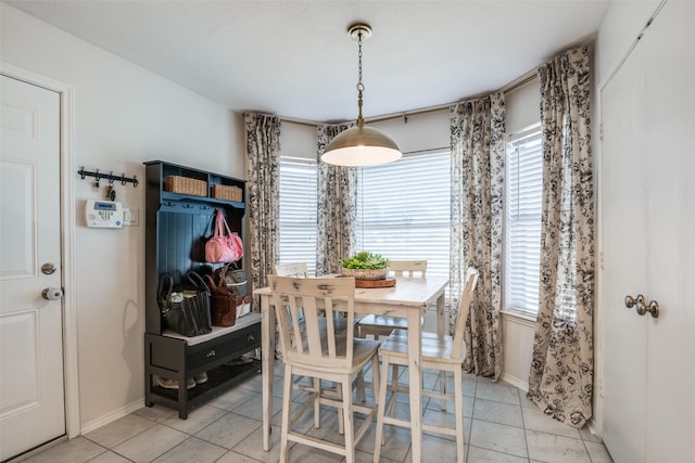dining space featuring baseboards, light tile patterned floors, and a healthy amount of sunlight