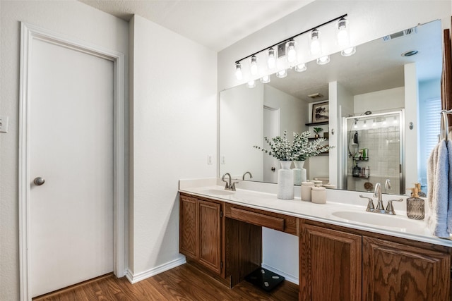 bathroom featuring visible vents, a stall shower, wood finished floors, and a sink