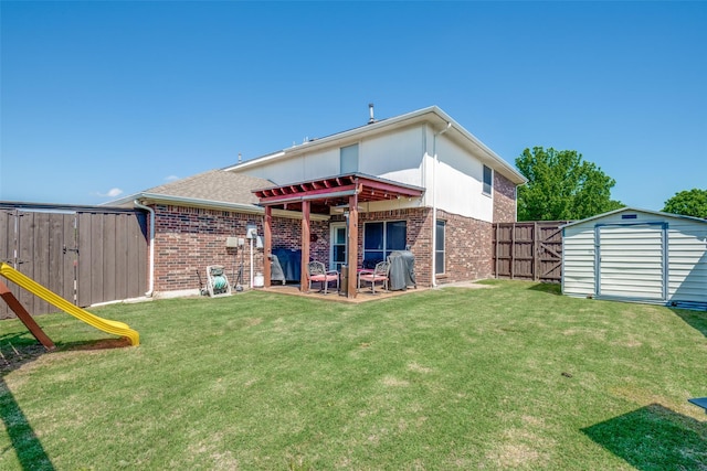 rear view of house with a lawn, a storage shed, brick siding, and a fenced backyard