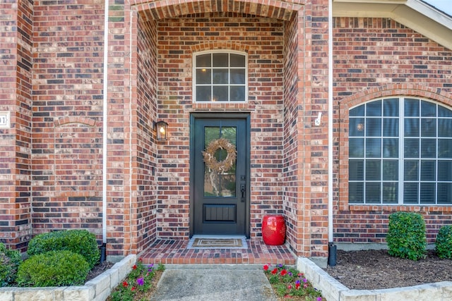 view of exterior entry with brick siding