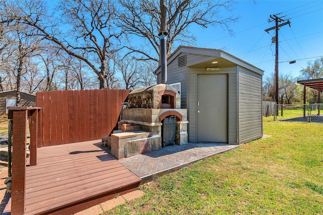 view of outbuilding featuring an outdoor structure and fence