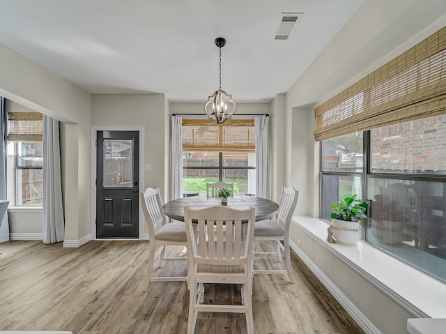 dining room with visible vents, a chandelier, light wood finished floors, and baseboards