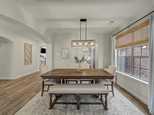 stairway featuring baseboards, arched walkways, ornamental molding, wood finished floors, and built in features
