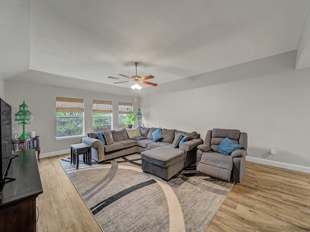 living area with visible vents, a ceiling fan, light wood-style flooring, and baseboards