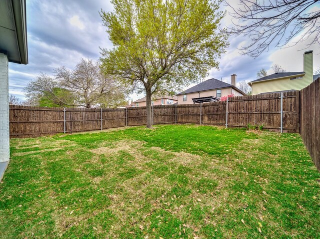 back of property featuring roof with shingles, a yard, a patio, and a fenced backyard