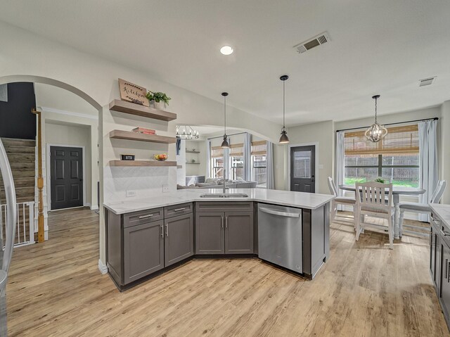 kitchen featuring light stone counters, a sink, appliances with stainless steel finishes, visible vents, and backsplash