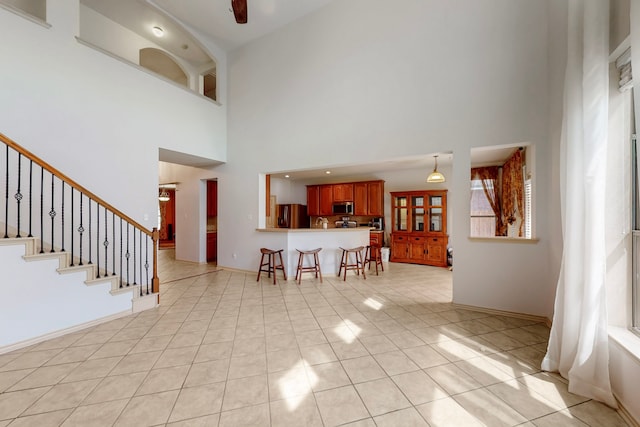 1312 Cattle Crossing Dr, Fort Worth, TX 76131 - living room with a towering ceiling, light tile patterned floors, baseboards, and stairway