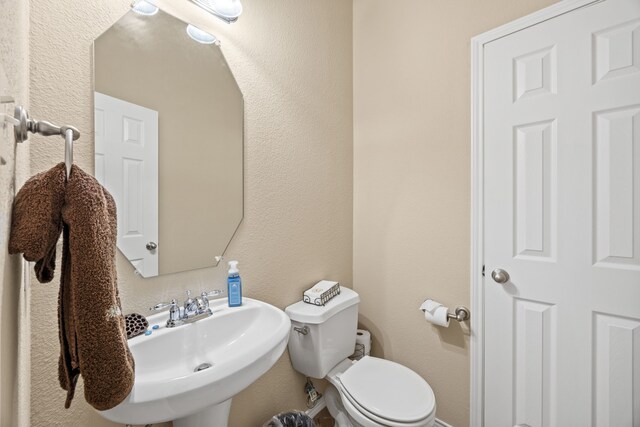 1192 Oak Hill Ln, Murphy, TX 75094 - bathroom featuring a sink, toilet, and a textured wall