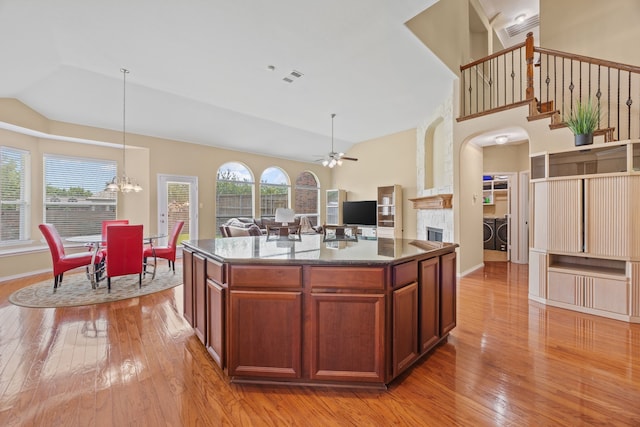 1192 Oak Hill Ln, Murphy, TX 75094 - kitchen with separate washer and dryer, light wood finished floors, a fireplace, ceiling fan, and high vaulted ceiling