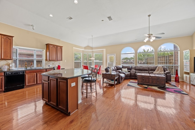 1192 Oak Hill Ln, Murphy, TX 75094 - kitchen featuring dishwasher, dark countertops, light wood finished floors, a kitchen breakfast bar, and a center island