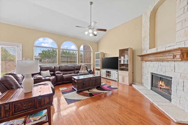 1192 Oak Hill Ln, Murphy, TX 75094 - living area featuring a ceiling fan, vaulted ceiling, a fireplace, and light wood-type flooring