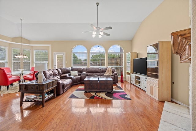 1192 Oak Hill Ln, Murphy, TX 75094 - living room with a chandelier, light wood finished floors, a ceiling fan, and high vaulted ceiling