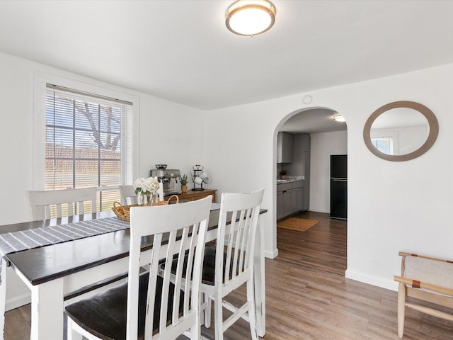 5536 Goodman Ave, Fort Worth, TX 76107 - dining area featuring arched walkways, wood finished floors, and baseboards