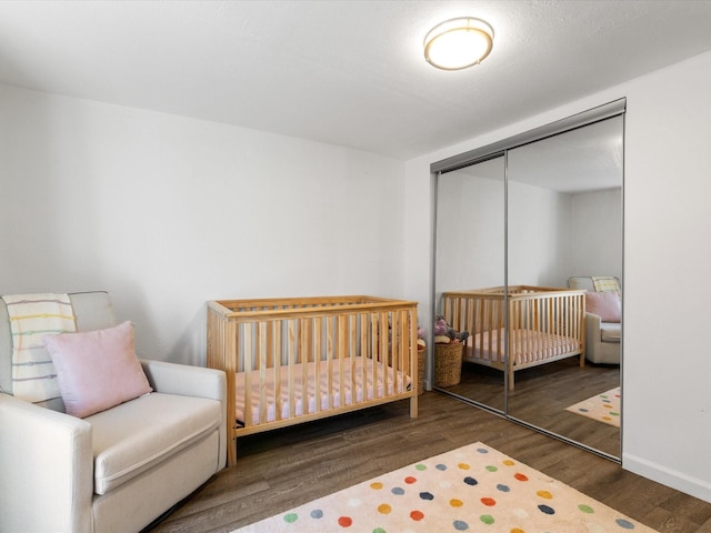 5536 Goodman Ave, Fort Worth, TX 76107 - bedroom featuring a closet, wood finished floors, a nursery area, and baseboards