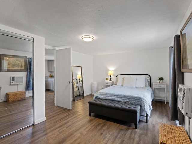 5536 Goodman Ave, Fort Worth, TX 76107 - bedroom with wood finished floors, a wall mounted AC, baseboards, and a textured ceiling