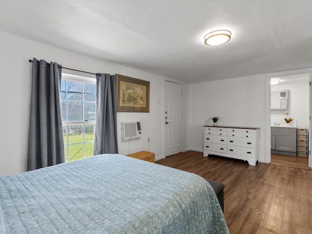 5536 Goodman Ave, Fort Worth, TX 76107 - bedroom with wood finished floors, a textured ceiling, a wall unit AC, ensuite bath, and baseboards