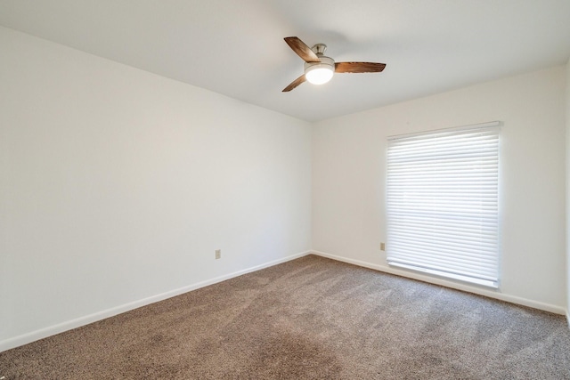 carpeted empty room with baseboards and a ceiling fan