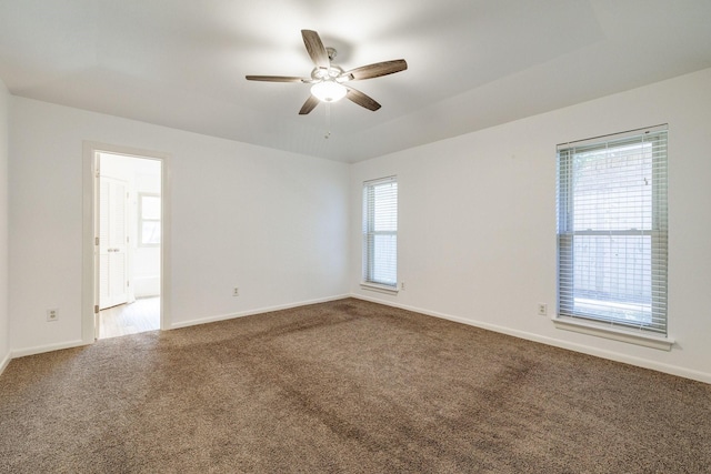 spare room featuring ceiling fan, carpet flooring, and baseboards