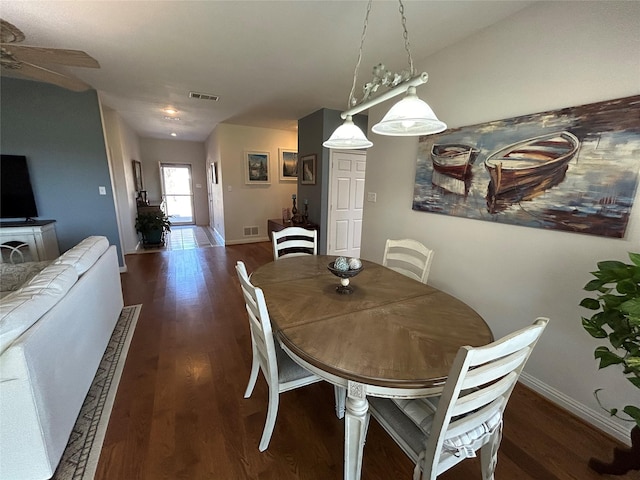 dining room featuring wood finished floors, visible vents, a ceiling fan, and baseboards