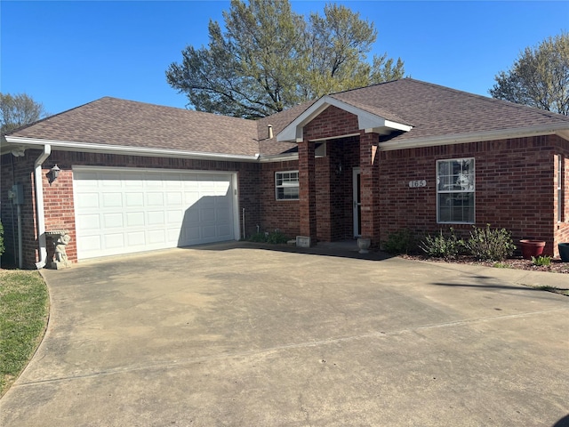 ranch-style home with concrete driveway, an attached garage, brick siding, and a shingled roof