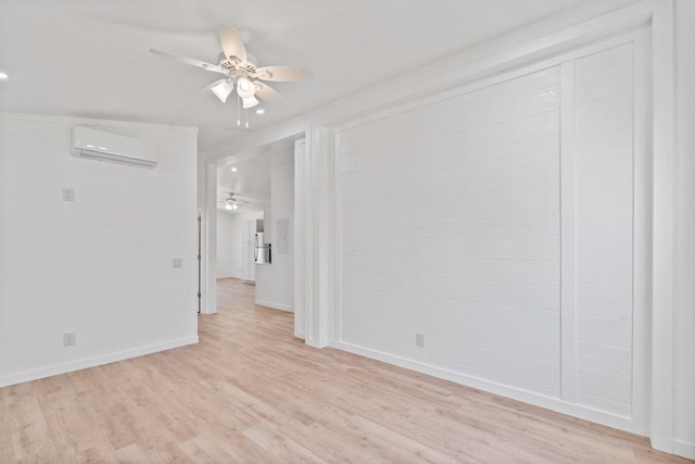 empty room featuring baseboards, light wood-style floors, ceiling fan, and a wall unit AC
