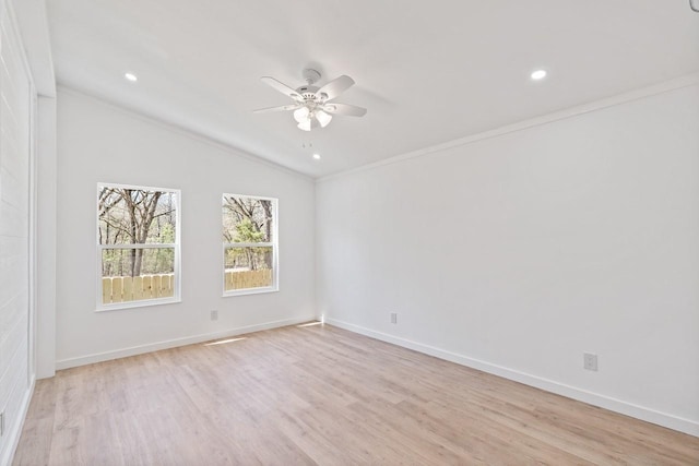 empty room featuring light wood-style flooring, baseboards, a ceiling fan, and vaulted ceiling