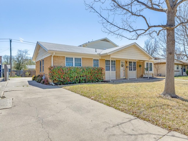 ranch-style house with brick siding, concrete driveway, a front lawn, and fence