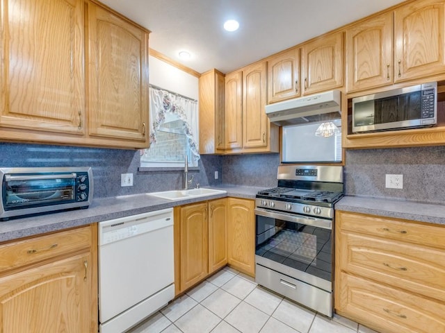 kitchen featuring light brown cabinets, under cabinet range hood, a sink, stainless steel appliances, and light tile patterned floors