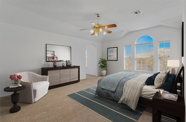 bedroom with visible vents, a ceiling fan, arched walkways, lofted ceiling, and light colored carpet