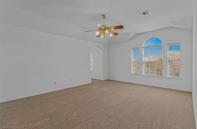 empty room featuring light carpet, visible vents, lofted ceiling, and a ceiling fan