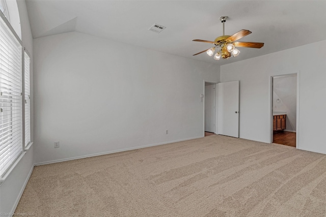unfurnished bedroom with visible vents, connected bathroom, a ceiling fan, lofted ceiling, and carpet floors