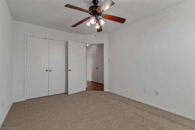 unfurnished bedroom featuring a closet, a ceiling fan, baseboards, and carpet