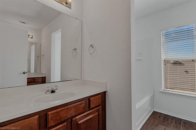 full bath featuring baseboards, visible vents, wood finished floors, and vanity
