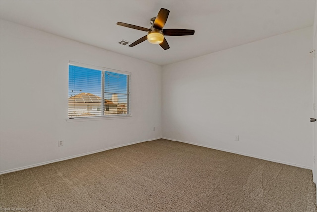 carpeted empty room with baseboards, ceiling fan, and visible vents