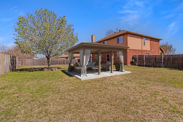 rear view of house with a fenced backyard, a patio, brick siding, and a yard