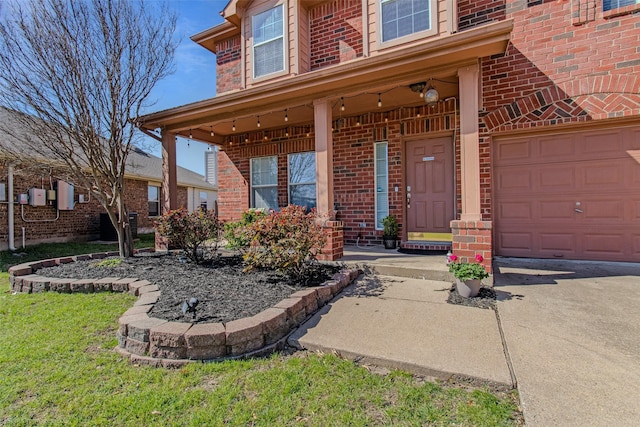 property entrance with a garage, brick siding, and concrete driveway