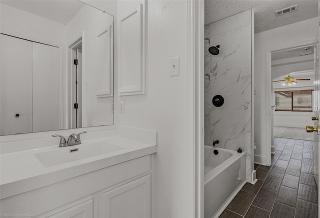 full bathroom featuring vanity, shower / bath combination, a textured ceiling, visible vents, and ceiling fan