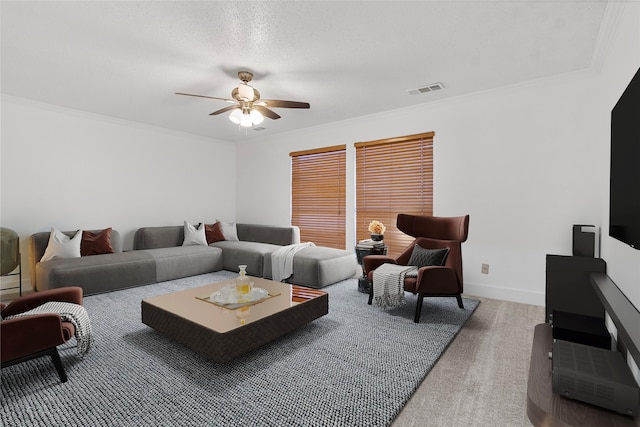 living area featuring crown molding, carpet, baseboards, ceiling fan, and visible vents