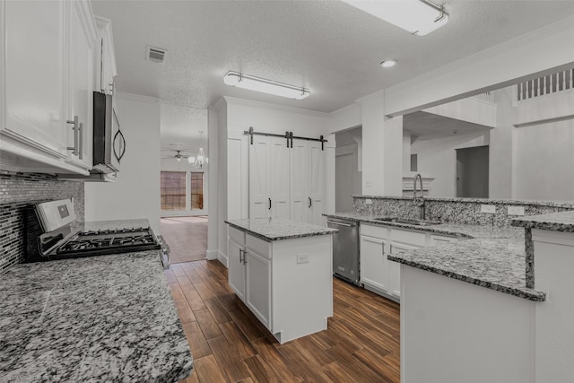 kitchen featuring a sink, white cabinetry, appliances with stainless steel finishes, dark wood finished floors, and visible vents