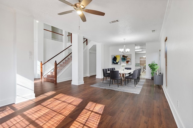 dining room with stairway, ceiling fan with notable chandelier, a textured ceiling, dark wood-style floors, and visible vents